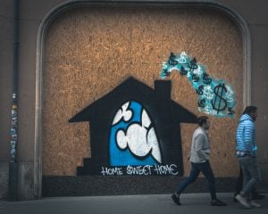 graffiti drawing of a home with dollar signs coming out of the chimney