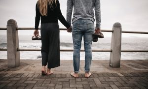 couple holding hands by the waterfront