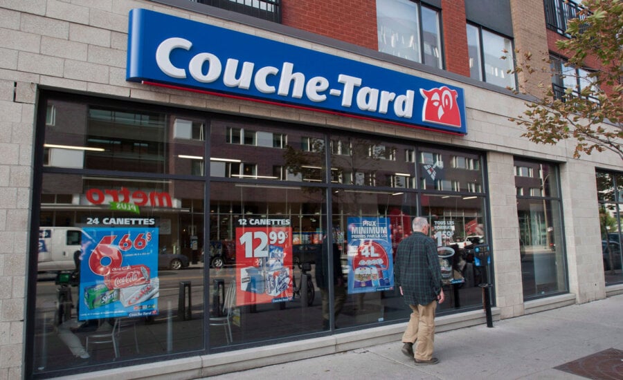 A man passes by a Couche Tard convenience store in Montreal, Friday, October 5, 2012. Alimentation Couche-Tard Inc. says its net earnings fell by almost a third in its fourth quarter as inflation-squeezed consumers watch their spending.