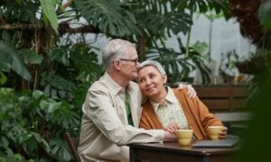 A retired couple sit with a cup of coffee