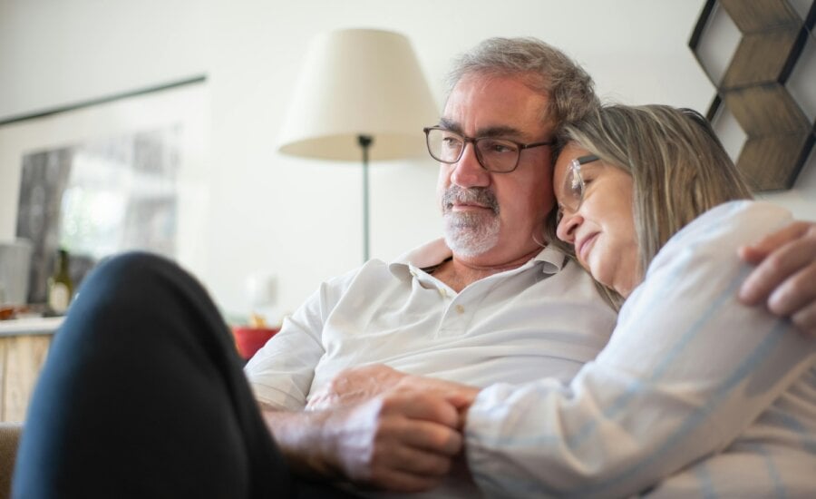 worried senior couple embraces