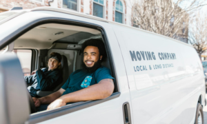 Two movers sit in the front of their van