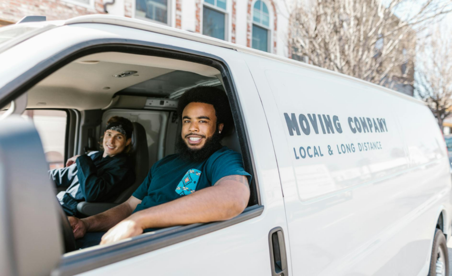 Two movers sit in the front of their van