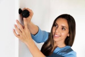 Woman adjusts home security camera