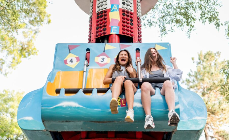 Two girls screaming on an amusement park ride