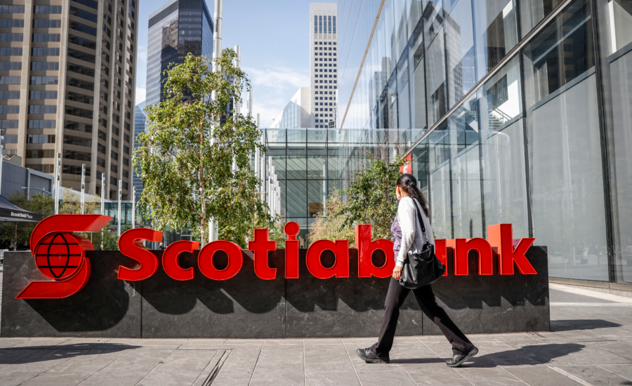 A woman walks past a Scotiabank sign