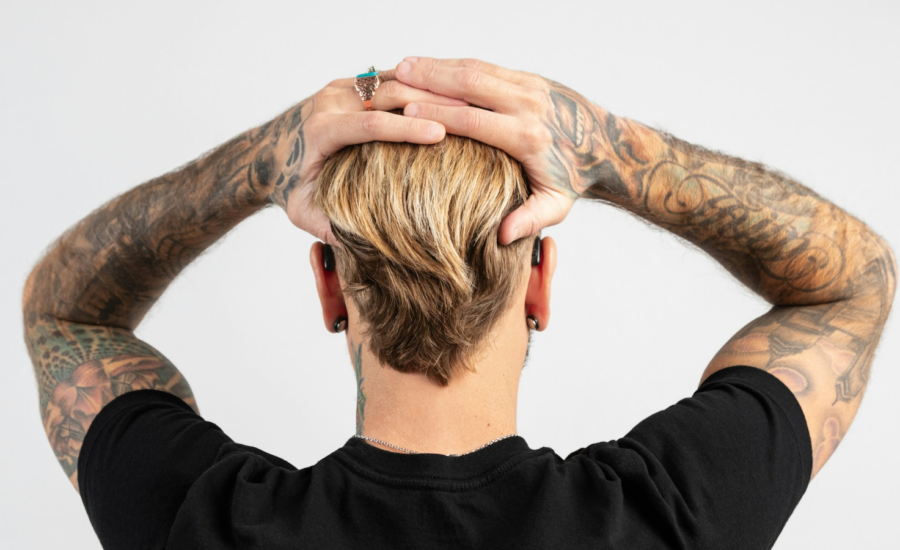 Rear view of young man wearing small hearing aids