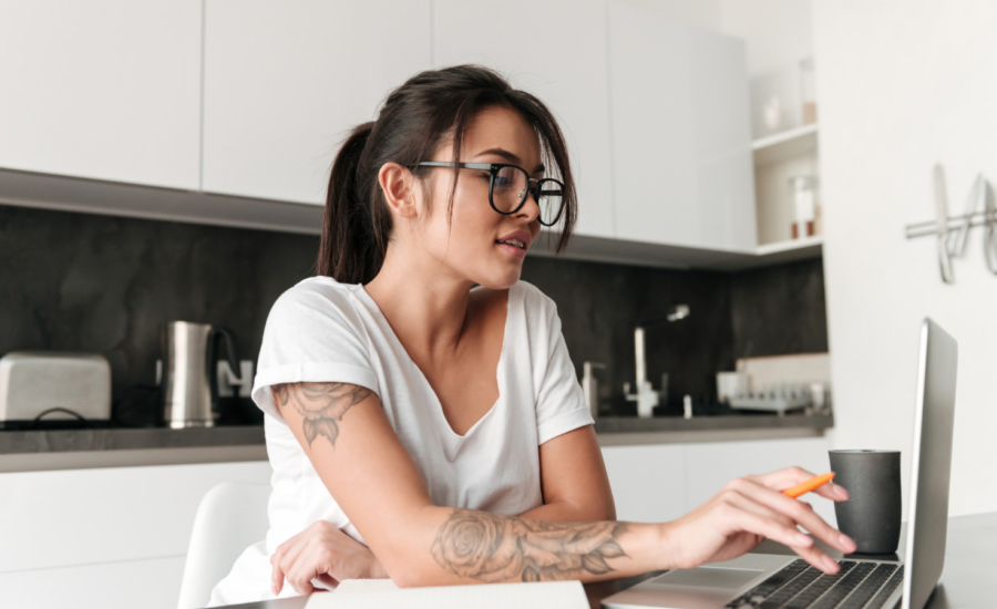 A young woman using a laptop in her kitchen