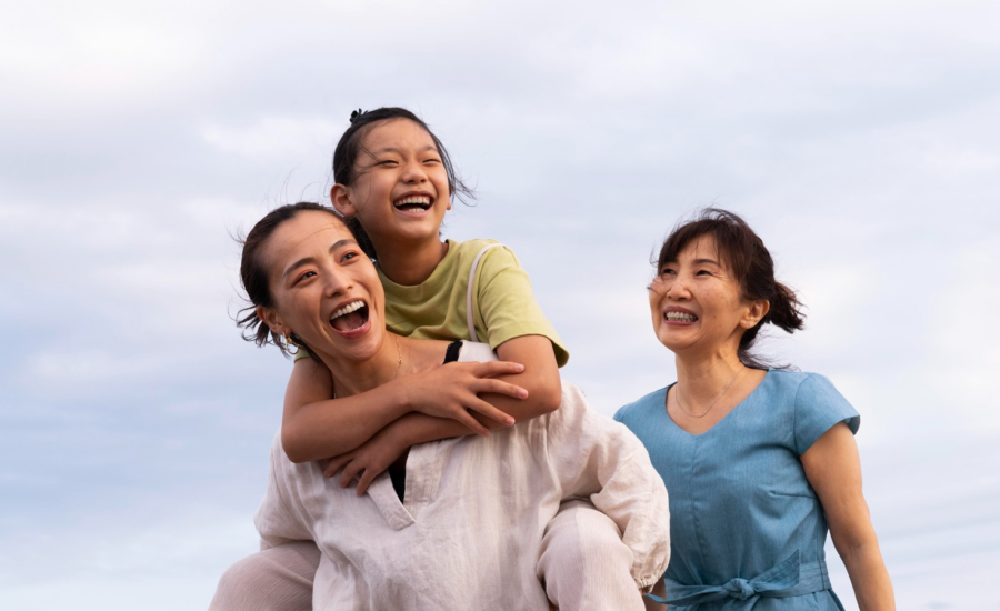 A grandmother, daughter and granddaughter walk on a beach