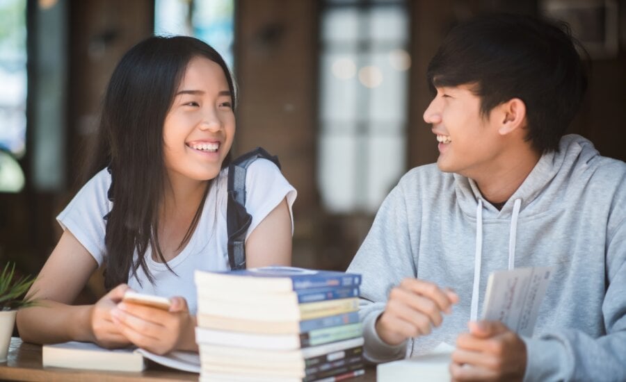 university students at library table