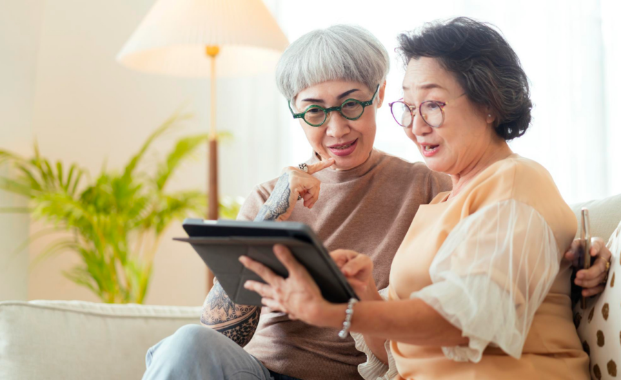 Two middle-aged women check interest rates on a tablet