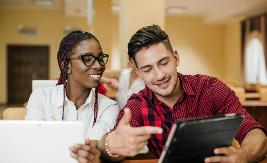 A young man and woman look at crypto data on a tablet