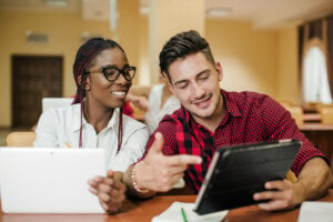 A young man and woman look at data on a tablet