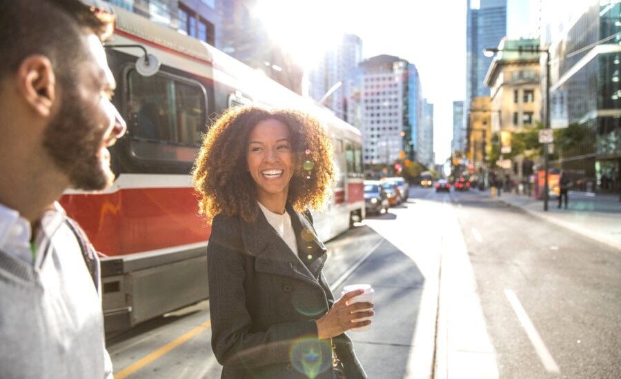 A man and woman chat as they cross a downtown Toronto street