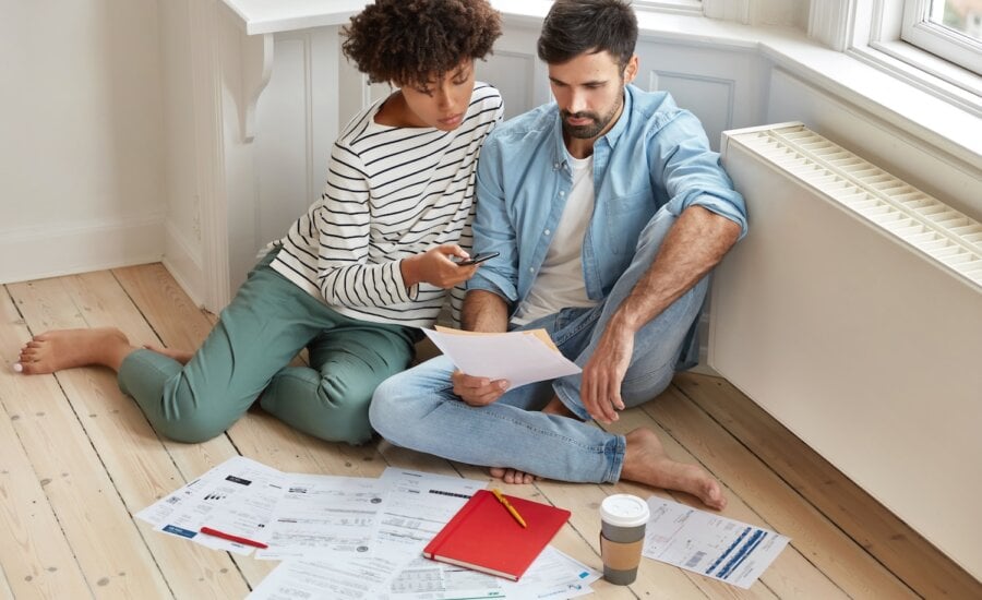 couple examines mortgage renewal documents on living room floor