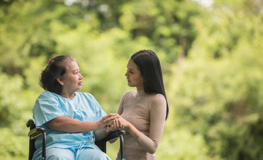 Elderly woman in wheelchair with granddaughter