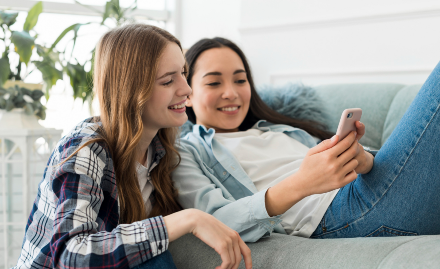 Two young women look at a bank promo offer on a phone