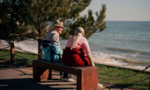 Couple talking on a bench about what happens to their RRIFs when one dies