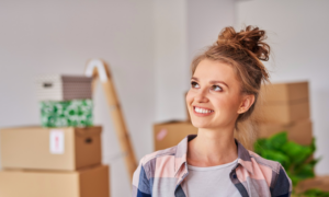 A young woman surrounded by moving boxes in her new home