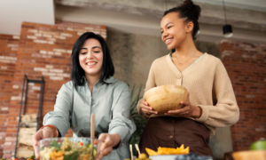 Two young women prepare food for a dinner party