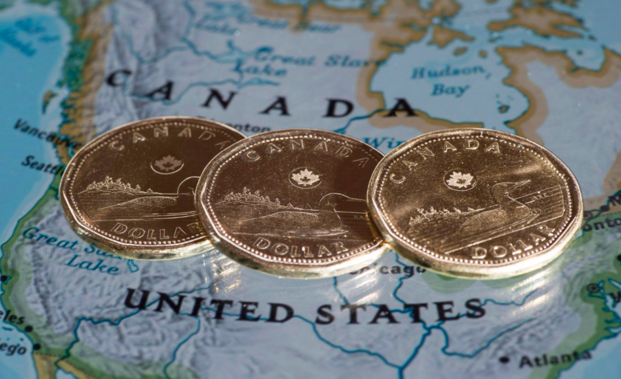 Three loonies sit on a map on the Canadian-U.S. border