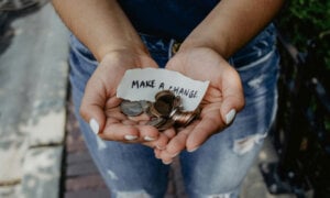 A hand holding money and a note that reads "Make a change." This symbolizes how Canadians are making charitable donations for impact.