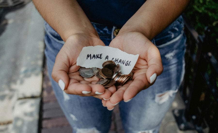 A hand holding money and a note that reads "Make a change." This symbolizes how Canadians are making charitable donations for impact.