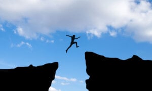 A Canadian jumping over gap, to symbolize managing risks in a portfolio with ETFs.