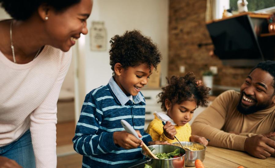 Parents cook with their two young kids