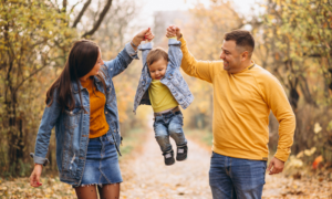 A young couple walks with their toddler son.