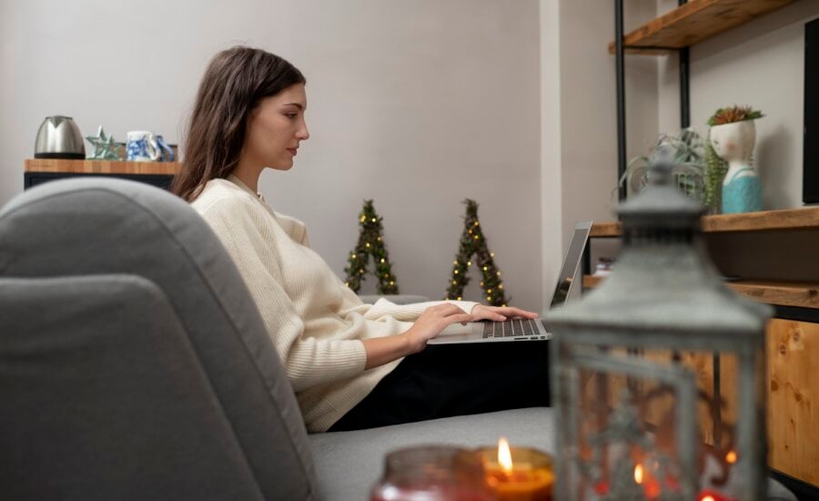 woman works on laptop December indoor scene