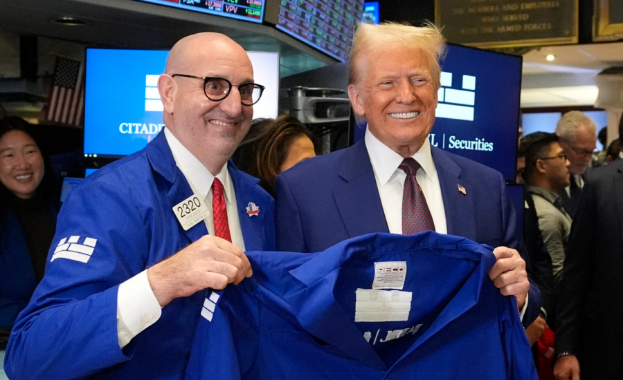 Donald Trump is given a jacket by trader Peter Giacchi at the New York Stock Exchange,