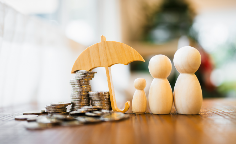 Wooden figurines of a family and an umbrella sheltering stacks of coins