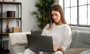 A Canadian woman at home, looking at her loan options online, including secured vs unsecured loans.