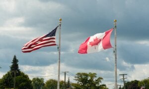 American and Canadian flags waving side by side