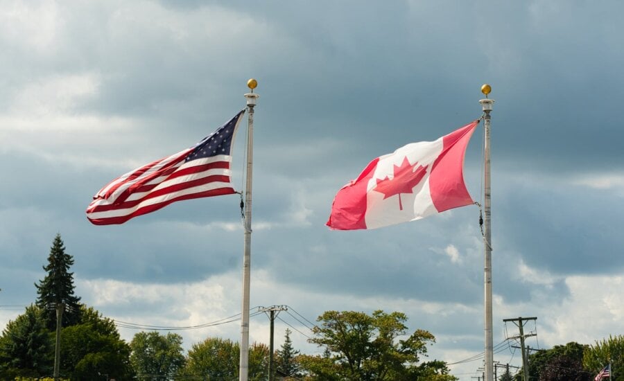 American and Canadian flags waving side by side