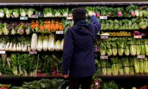 A man browses a supermarket produce aisle