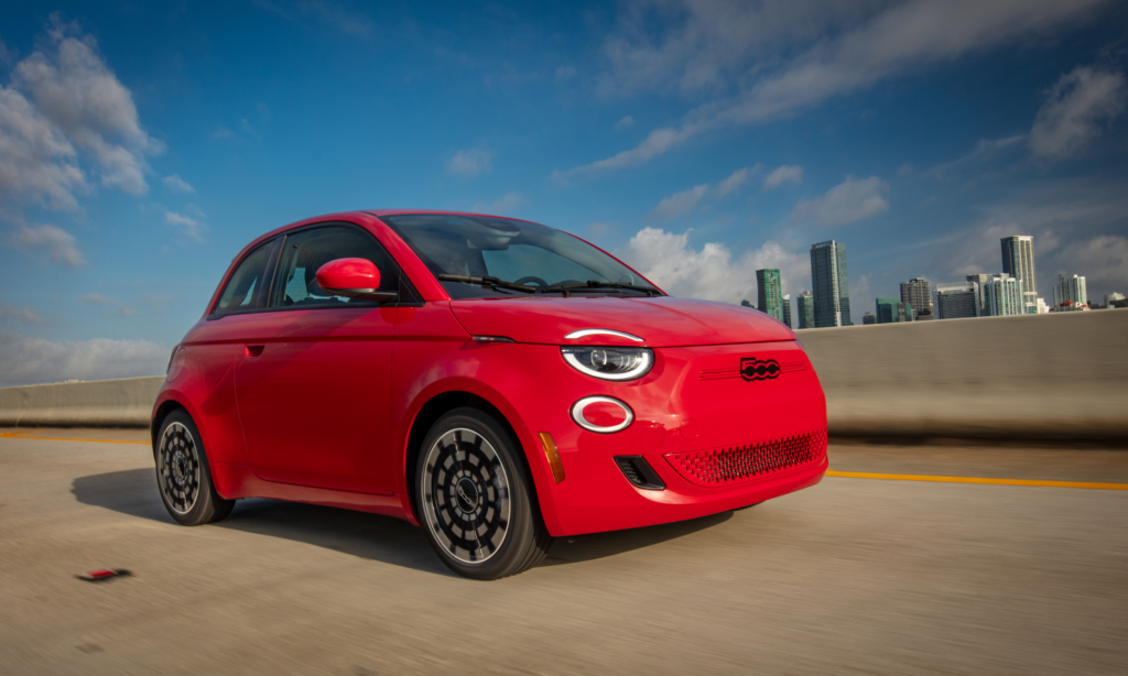 A Fiat 500e drives on a highway