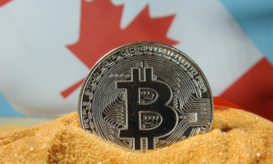 A bitcoin sits in front of a Canadian flag