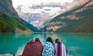 A family of four sits by Lake Louise in Banff, Alberta