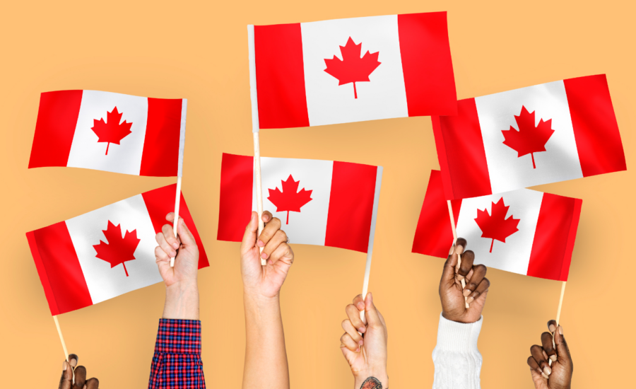 Six hands hold up Canada flags